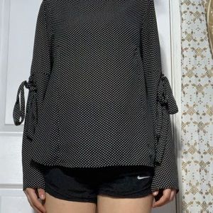 A black with white polka dot blouse
